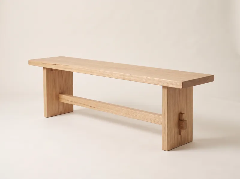 Denham: a long backless timber bench on two solid slab ends joined by a stretcher with a wedged through-tenon